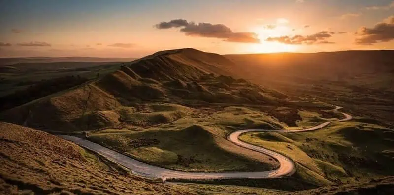 winding road through mountains at sunset